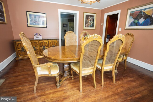 dining space featuring an inviting chandelier, dark hardwood / wood-style flooring, and crown molding