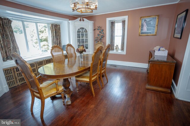 dining room with a wealth of natural light, ornamental molding, dark hardwood / wood-style flooring, and a notable chandelier