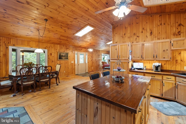 kitchen featuring wood counters, wood ceiling, a center island, hanging light fixtures, and light hardwood / wood-style flooring