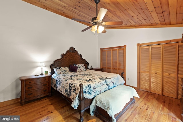 bedroom featuring multiple closets, ceiling fan, vaulted ceiling, and light wood-type flooring