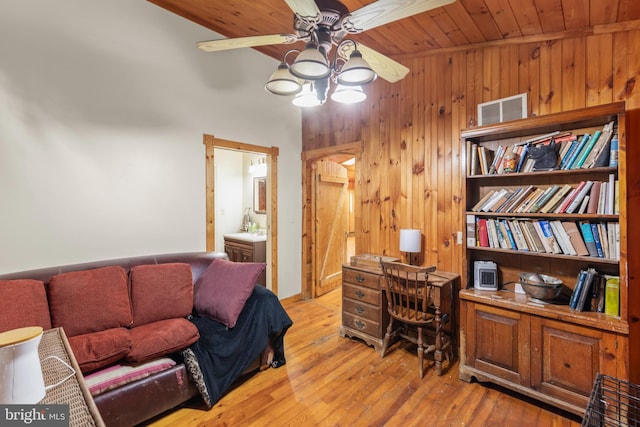 office with sink, wood ceiling, light hardwood / wood-style flooring, ceiling fan, and wood walls