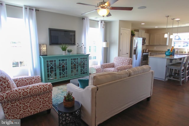 living room featuring dark wood-type flooring and ceiling fan