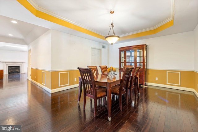 dining area with dark wood-type flooring and crown molding