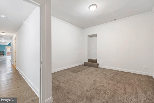 spare room with crown molding and light wood-type flooring