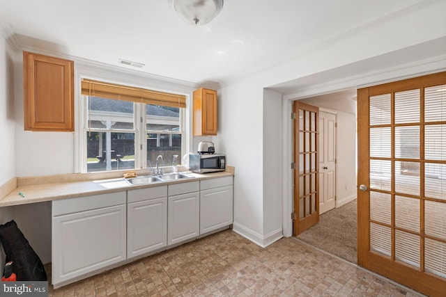 kitchen featuring white cabinetry and sink