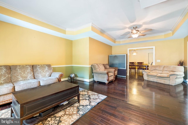 living room featuring crown molding, a raised ceiling, ceiling fan, and dark wood-type flooring