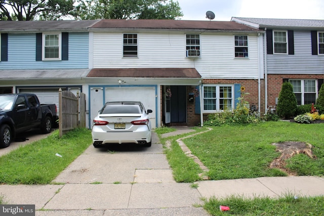 townhome / multi-family property featuring a front lawn and a garage