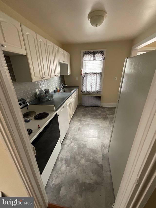 kitchen featuring backsplash, radiator, and white appliances