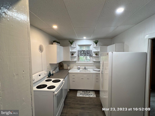 kitchen with a paneled ceiling, white appliances, white cabinets, sink, and dark hardwood / wood-style flooring