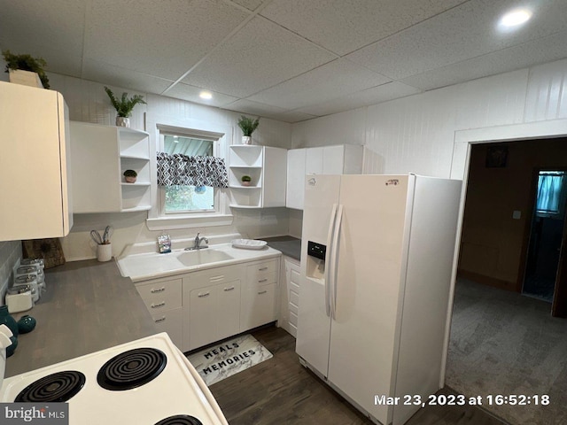 kitchen featuring white fridge with ice dispenser, sink, dark hardwood / wood-style floors, stove, and white cabinets