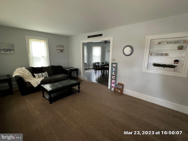 living room with dark carpet and a wealth of natural light