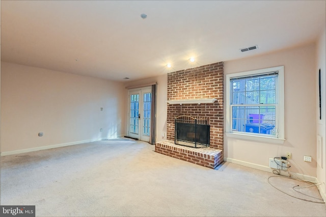 unfurnished living room with a brick fireplace and carpet