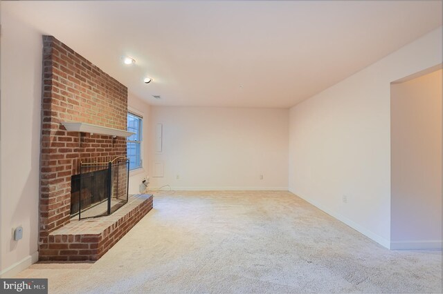 unfurnished living room featuring a brick fireplace and light colored carpet