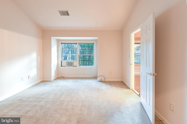 carpeted spare room with vaulted ceiling