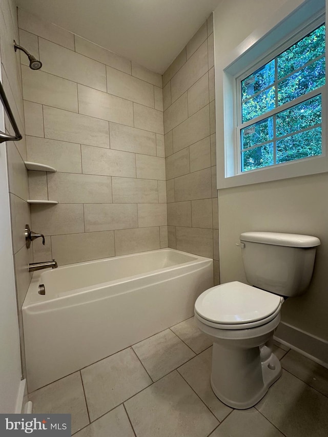 bathroom featuring tile patterned floors, tiled shower / bath combo, and toilet