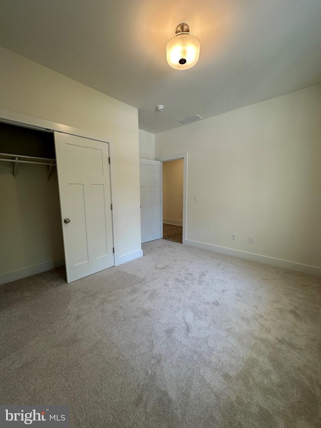 unfurnished bedroom featuring carpet floors and a closet