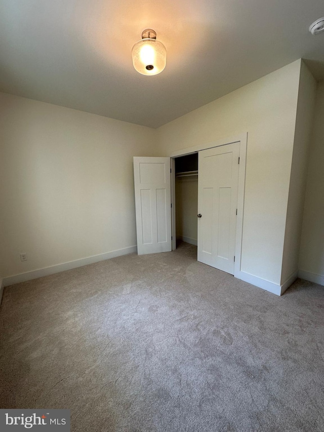 unfurnished bedroom with carpet flooring and a closet