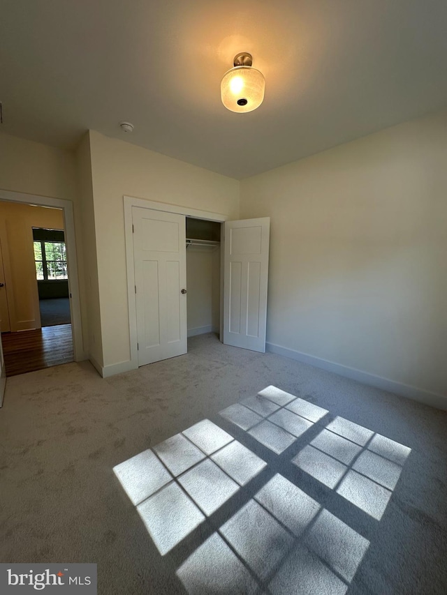 unfurnished bedroom featuring carpet floors and a closet