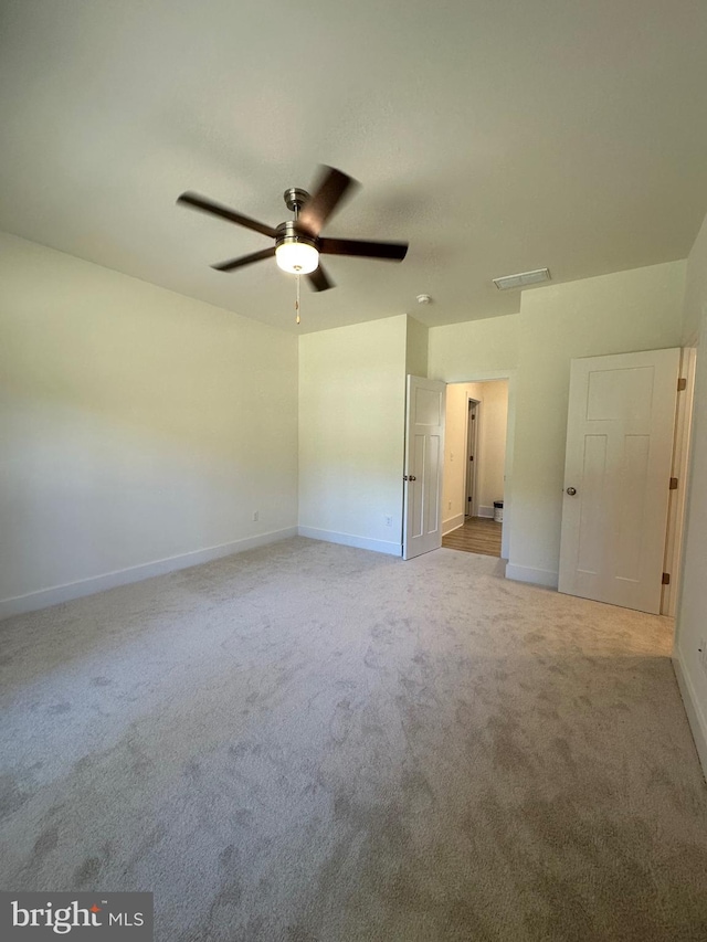 spare room featuring ceiling fan and light colored carpet