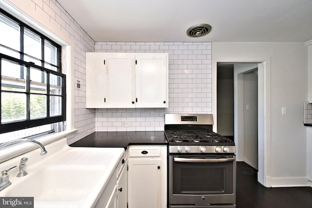 kitchen featuring white cabinetry, tasteful backsplash, stainless steel range with gas stovetop, and sink