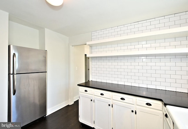 kitchen with decorative backsplash, stainless steel fridge, white cabinetry, and dark hardwood / wood-style floors