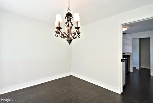 unfurnished dining area with dark hardwood / wood-style floors and a chandelier