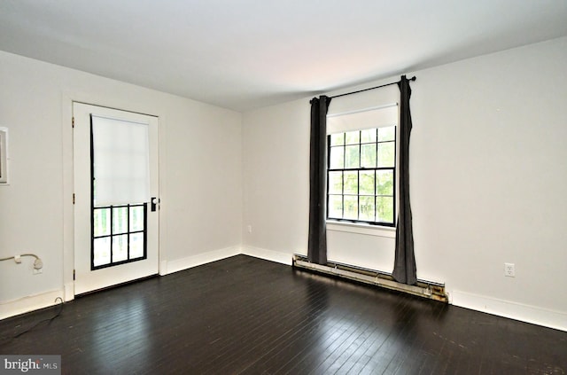 unfurnished room with baseboard heating and dark hardwood / wood-style flooring