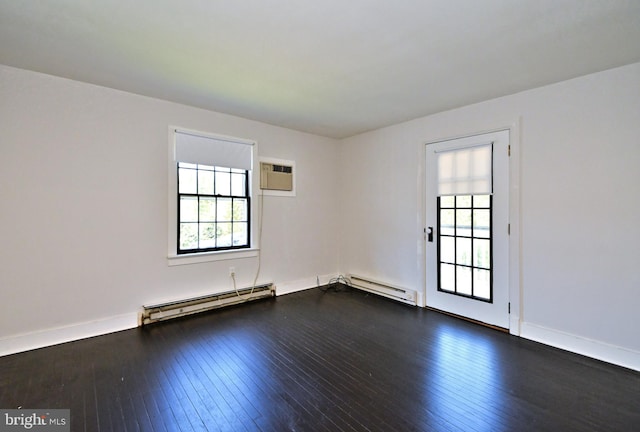 empty room with a baseboard heating unit, dark wood-type flooring, and an AC wall unit