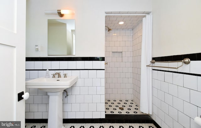 bathroom with tile walls, a tile shower, and tile patterned flooring