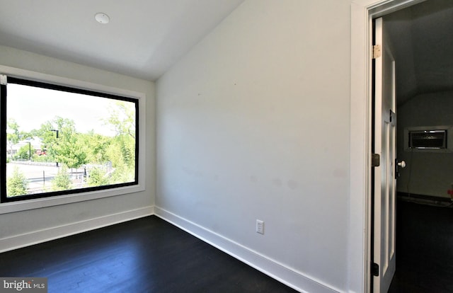 empty room featuring dark wood-type flooring and lofted ceiling