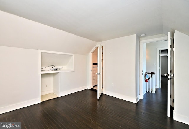 bonus room with dark hardwood / wood-style floors and vaulted ceiling