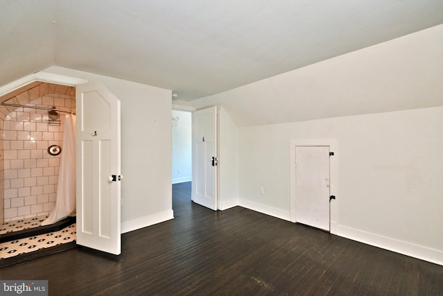 additional living space featuring vaulted ceiling and dark hardwood / wood-style floors