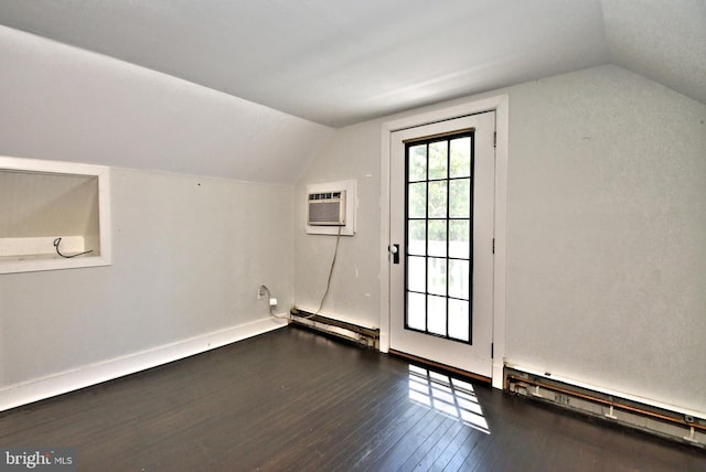 bonus room with an AC wall unit, dark wood-type flooring, a baseboard heating unit, and lofted ceiling