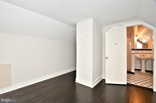 additional living space featuring vaulted ceiling and dark hardwood / wood-style floors