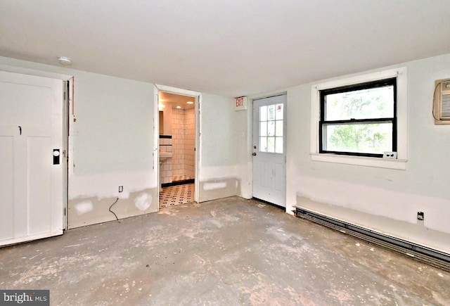 empty room with baseboard heating and concrete flooring