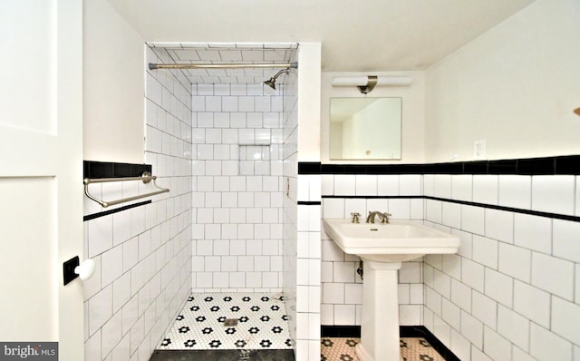 bathroom with sink, tile walls, tile patterned floors, and tiled shower