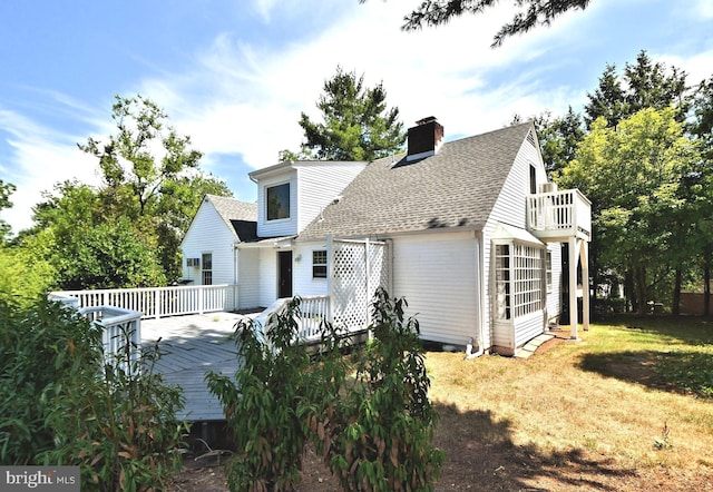 back of house featuring a wooden deck and a yard