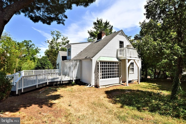 back of house featuring a wooden deck and a yard