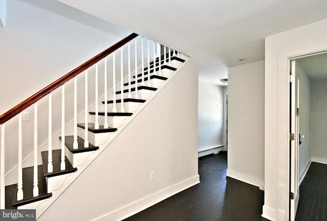 stairway featuring a baseboard heating unit