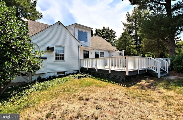 back of house with a deck, a yard, and a wall mounted air conditioner