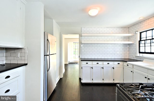 kitchen with white cabinetry, stainless steel fridge, range with gas cooktop, and tasteful backsplash