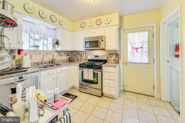 kitchen with stainless steel appliances, backsplash, white cabinets, and sink