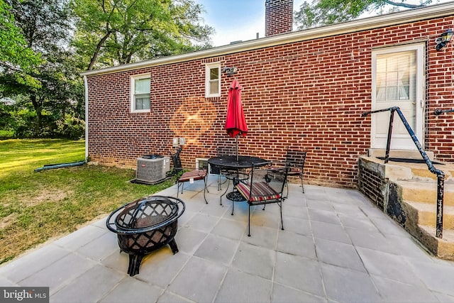 view of patio with cooling unit and an outdoor fire pit