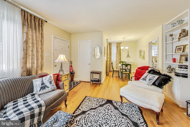 living room featuring light hardwood / wood-style flooring and a notable chandelier