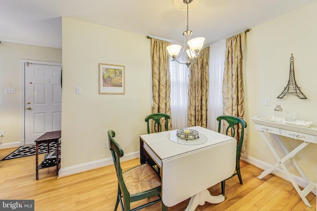 dining room featuring wood-type flooring and an inviting chandelier