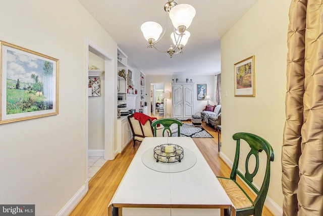 dining room with light hardwood / wood-style flooring and a chandelier