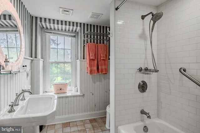 full bathroom featuring tiled shower / bath combo, sink, and toilet