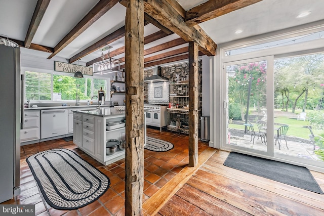 kitchen with beam ceiling, a wealth of natural light, stainless steel fridge, and white dishwasher