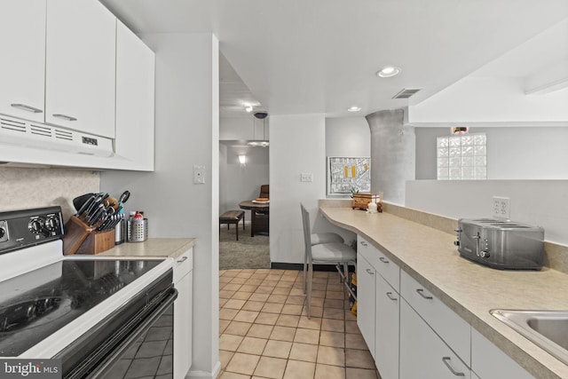 kitchen featuring light tile patterned floors, white cabinets, sink, and black range with electric cooktop