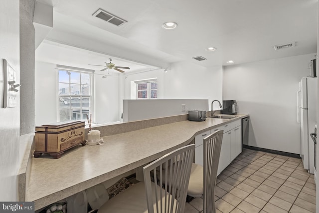 kitchen with white fridge, light tile patterned floors, ceiling fan, dishwasher, and sink